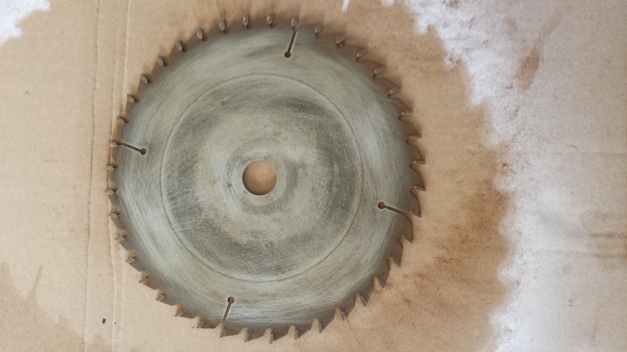 A sanded steel saw blade (sanded to remove the rust). This is the 2nd saw blade MuscularTeeth has drawn on.